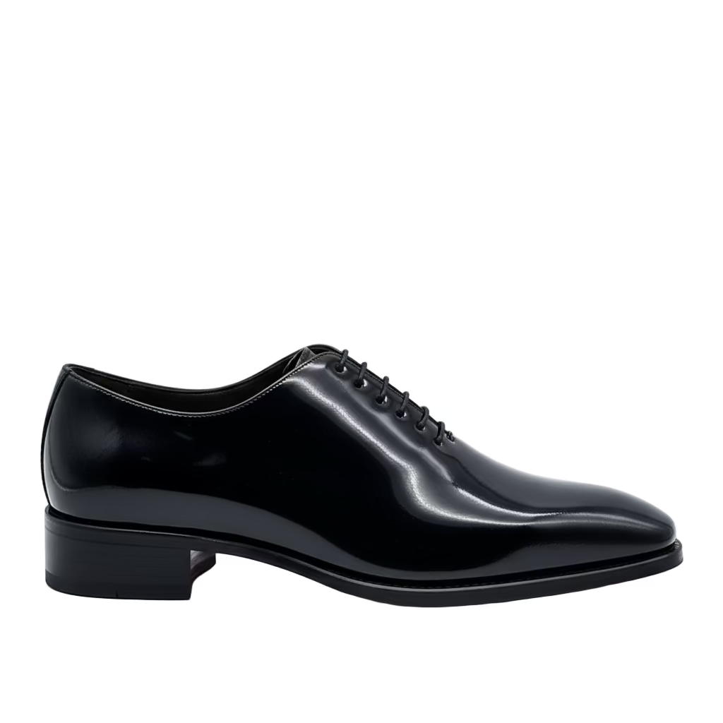 Black patent leather dress shoe on a white background
