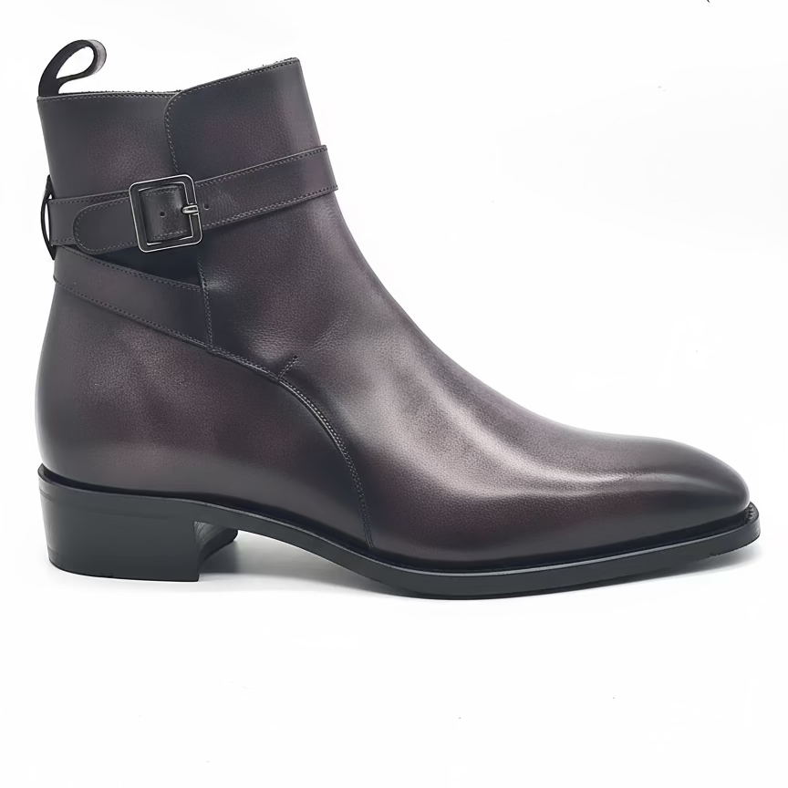 A pair of Atilla Jodhpur boots with aubergine patina, featuring a strap-and-buckle fastener, Goodyear Welt leather sole with a Cuban heel, and a black calf leather lining.