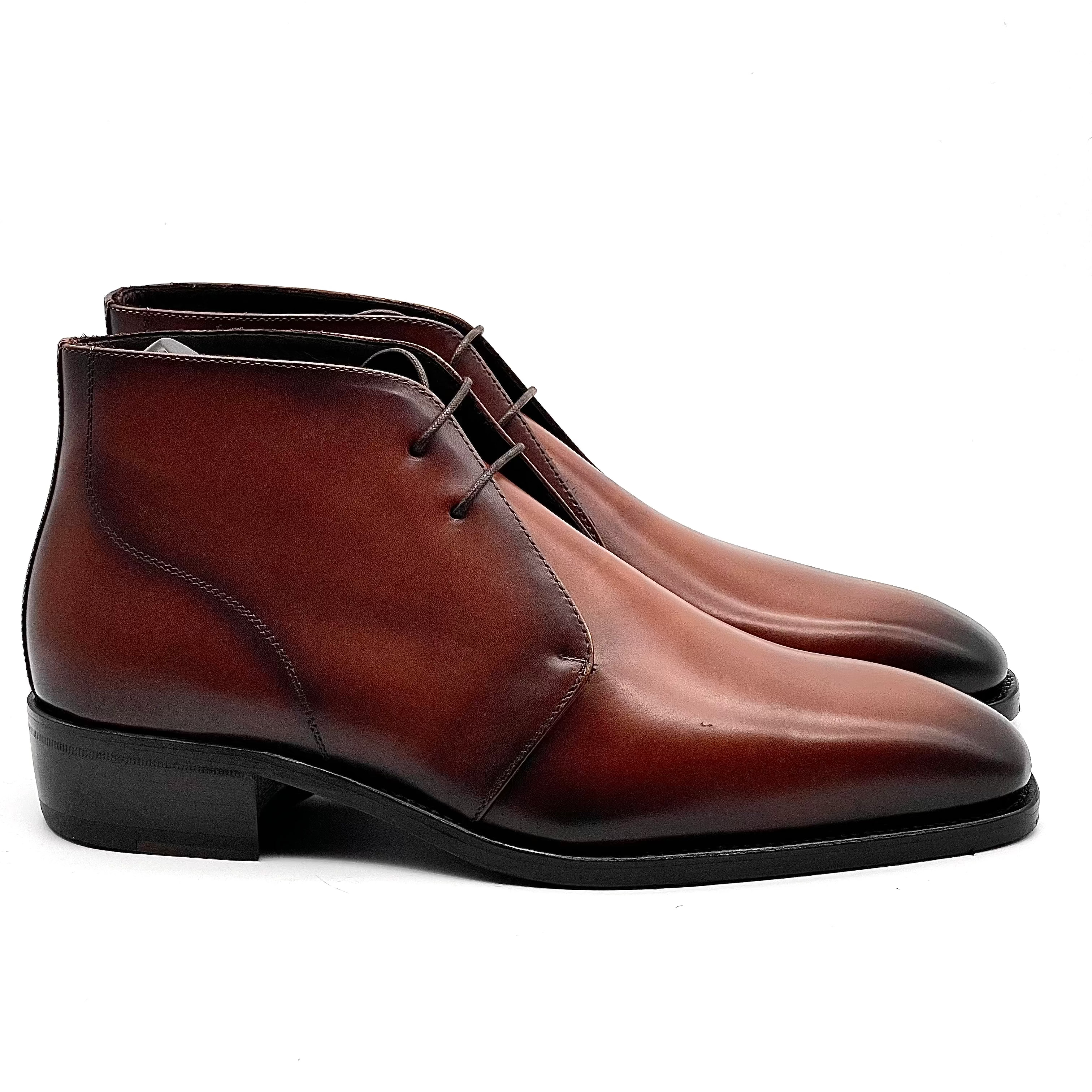 Pair of brown leather dress boots on a white background