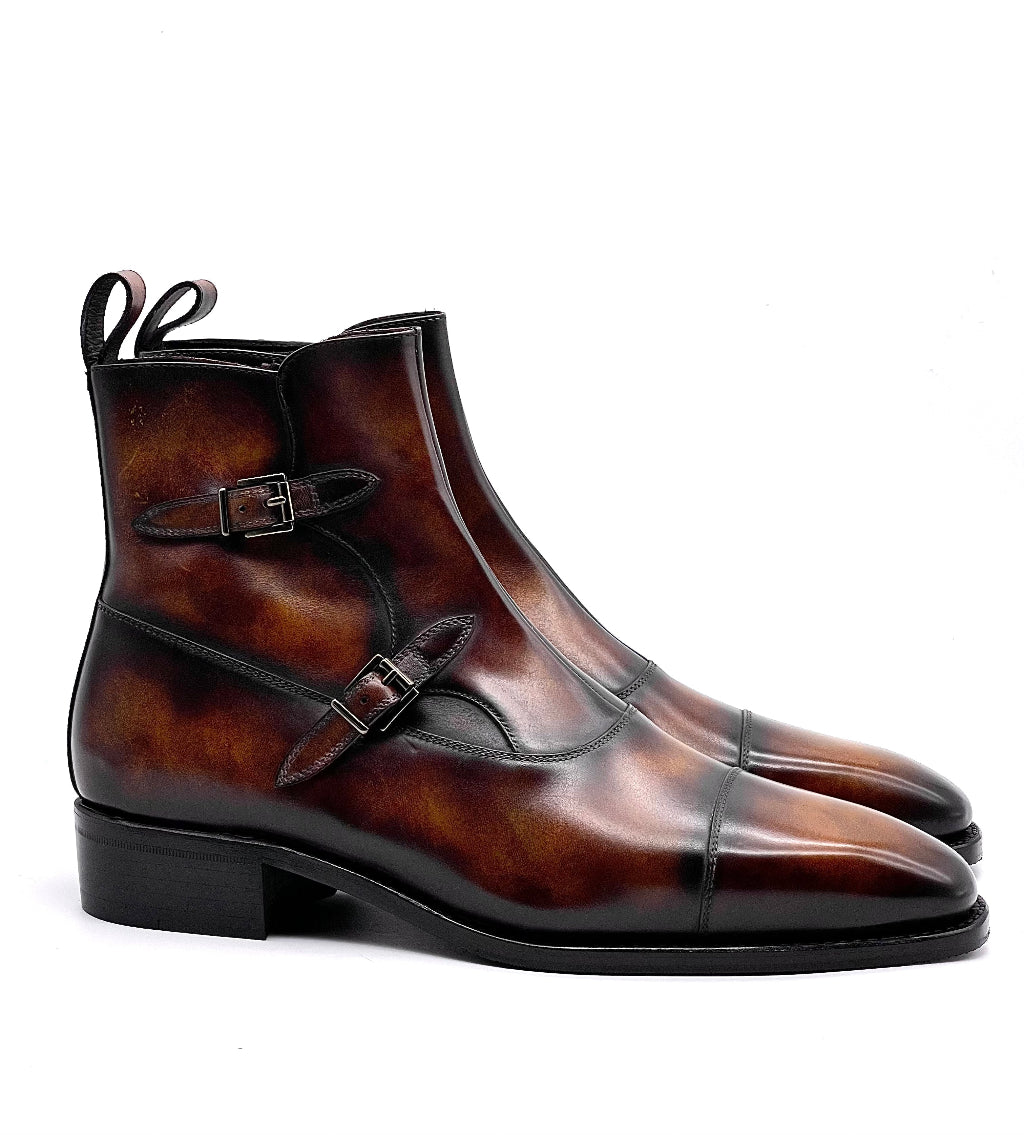 Brown leather boots with double buckle design on a white background