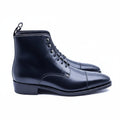 A pair of black leather lace-up boots with a straight toe cap and dark red Goodyear leather sole.