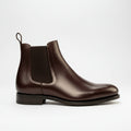 A pair of brown leather Chelsea boots with elastic side panels and a round toe.