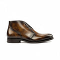 A brown chukka boot with a patina finish and a rounded toe.