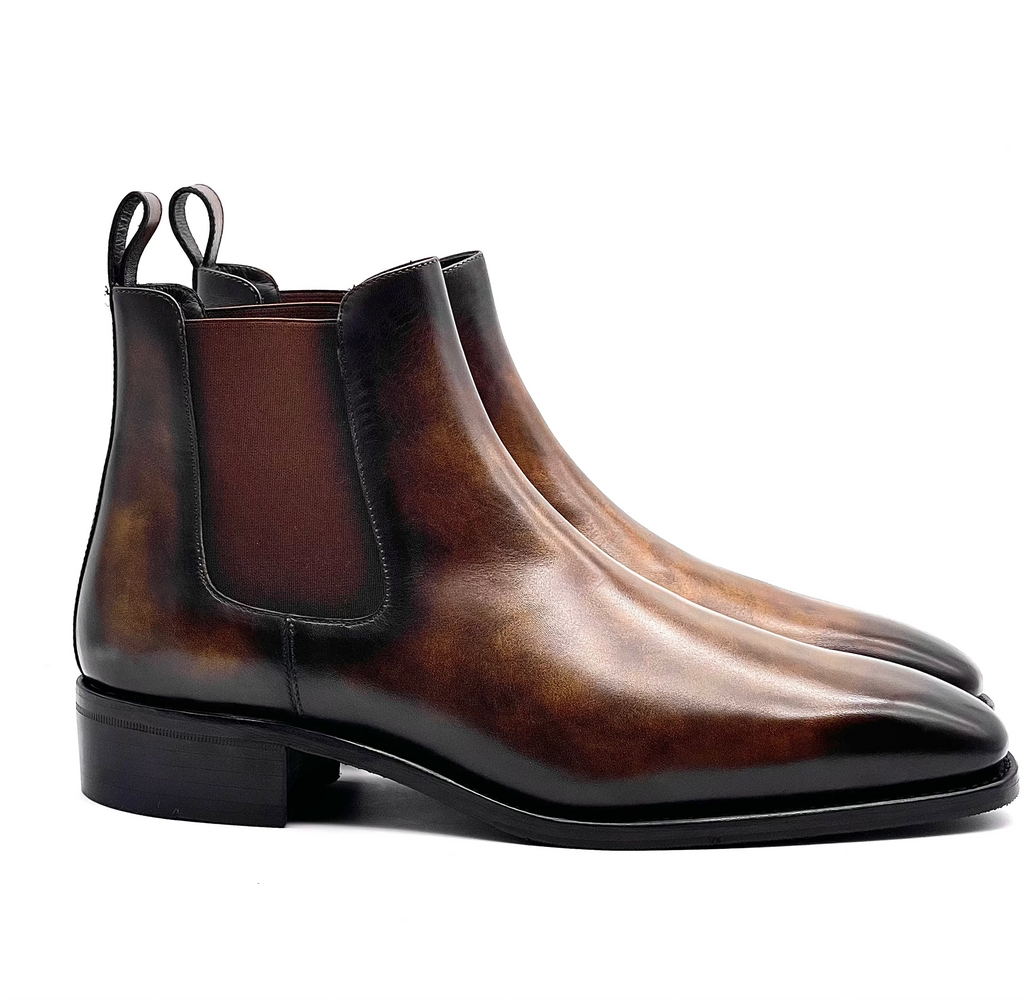 Pair of brown leather Chelsea boots on a white background